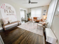 a living room with hardwood floors and a sign that says the peach on the beach